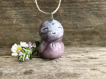 Blue-violet and purple raku ceramic smiley Jizo pendant strung on adjustable eco flax cord.