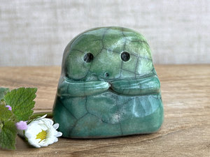 A sweet little kodama nature spirit ceramic guardian statue glazed in shades of green and with a lovely, gentle face and little arms.