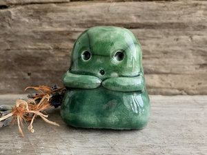 A sweet little kodama nature spirit ceramic guardian statue glazed in shades of green and with a lovely, gentle face and little arms.