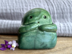 A sweet little kodama nature spirit ceramic guardian statue glazed in shades of green and with a lovely, gentle face and little arms.