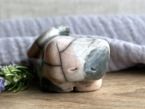 Little raku ceramic cat spirit kami sculpture glazed in a calico pattern (soft, pale orange, grey, and white) and with a kind, gentle, and sleepy face.