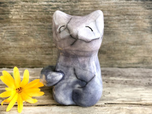 Raku ceramic sitting fox glazed in a gradient from soft indigo-violet to soft mauve (bottom to top). It has a kind face, and its tail is curled around it.