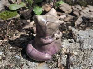 Raku ceramic kitsune fox sculpture. She has sweet praying hands and a gentle, upturned face. She is glazed in a warm, pale brown with soft mauve pink on her tail and lower half.