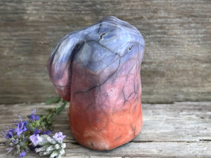 Raku ceramic usagi rabbit kami nature spirit glazed in a bottom-to-top gradient of burnt orange to mauve to blue-violet. Its ears are folded down its back, and it has a kind, gentle face.