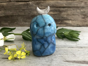 A kodama nature and forest spirit kami ceramic raku sculpture glazed in turquoise and blue with a crescent moon on its head.