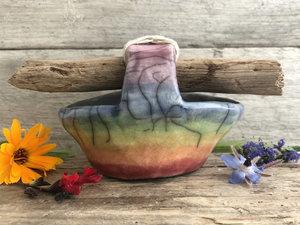 Raku ceramic basket with a driftwood handle. The basket is glazed in beautiful rainbow colours on the outisde, and the inside is left natural, unglazed black.