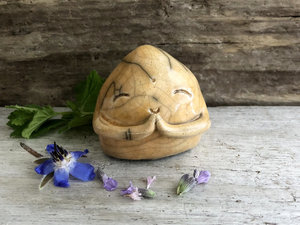A smiley, loving, and very happy Jizo Shinto raku ceramic sculpture talisman glazed in warm yellow-orange with sweet little praying hands.