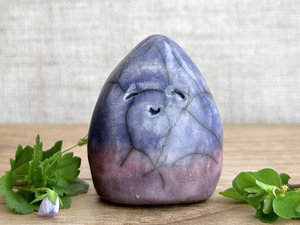 raku ceramic gnome spirit glazed in a bottom-to-top gradient of purple to indigo violet. it has a gentle, kind face.