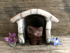 Small brown raku ceramic Shinto Inari kitsune fox kami sculpture with his very own little ceramic house. The house is glazed to look like it has a terracotta tiled roof and cherry blossom drifting across its white walls. A perfect mini shrine.