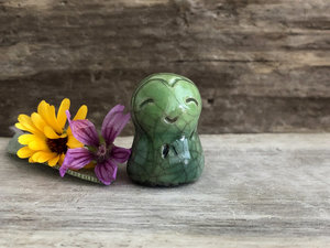A smiley and loving Jizo Shinto raku ceramic sculpture talisman glazed in leaf-green colours with a heart shape around his kind, smiling face. A wonderful smooth shape to hold in the hand.
