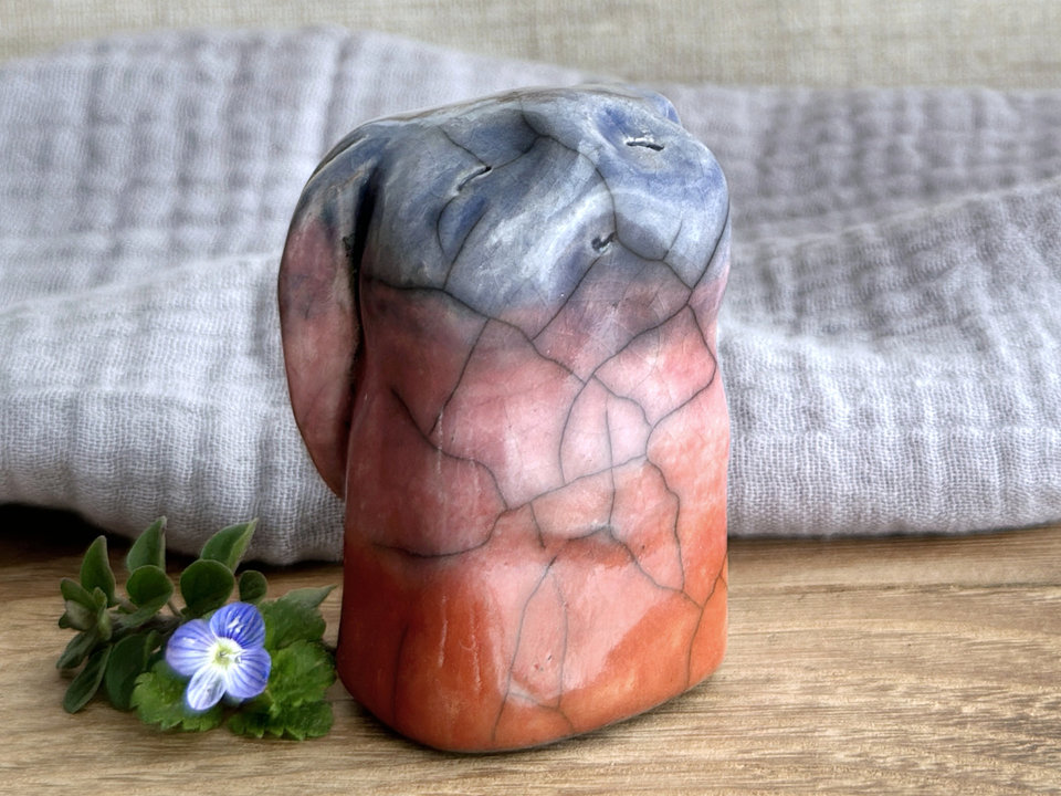 Raku ceramic usagi rabbit kami nature spirit glazed in a bottom-to-top gradient of burnt orange to mauve to soft indigo. Its ears are folded down its back, and it has a kind, gentle face.