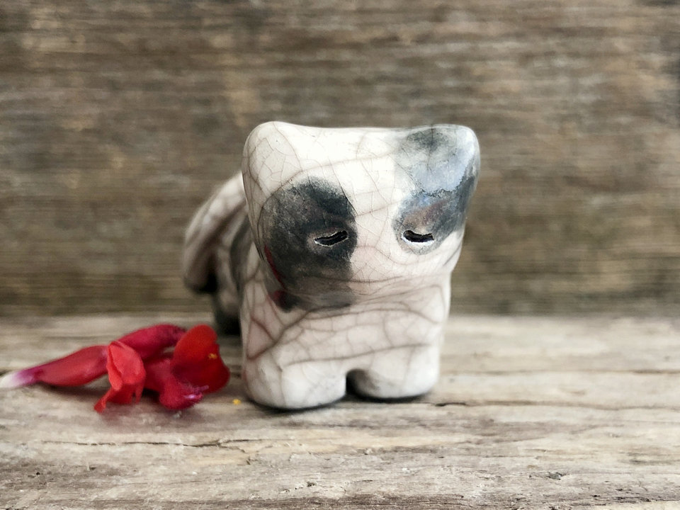 Little raku ceramic cat spirit kami sculpture glazed in dark grey and white. It has a kind, gentle, slightly sleepy face.