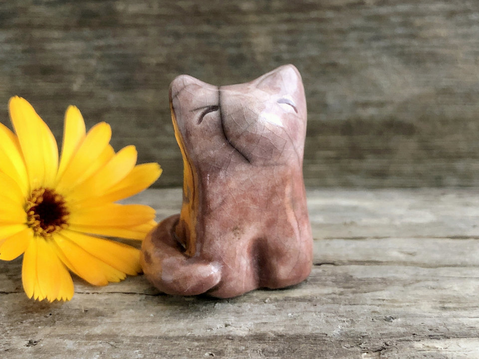 A sweet little Shinto Inari sitting kitsune fox kami spirit ceramic raku statue glazed in warm, soft orange and mauve colours.