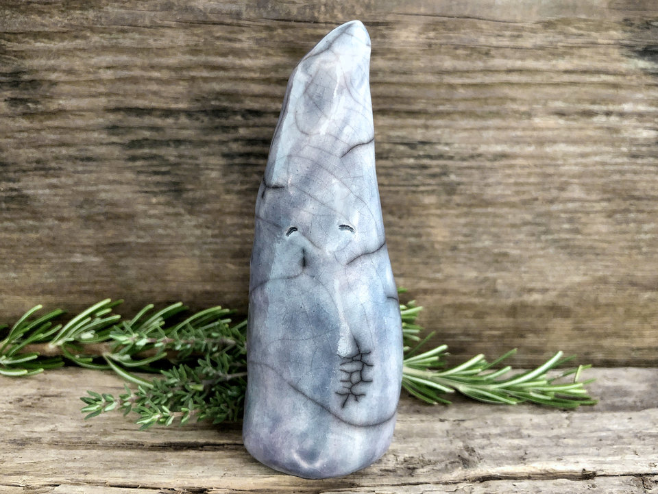Raku ceramic sculpture of a tall, pointy gnome. He is very friendly and glazed in a pale blue.