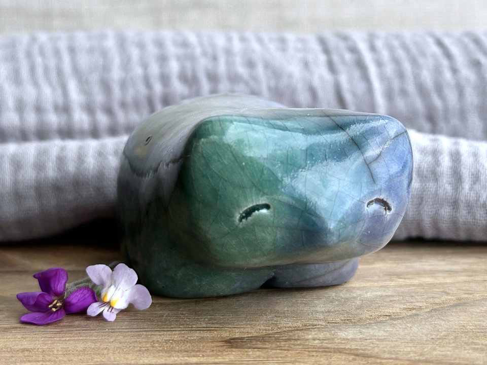 Ceramic raku bear kami sculpture glazed in forest green mostly on its left side and blue mostly on its right side. Where they overlap is a beautiful aqua colour. It has a kind, gentle face and is a little chonky.