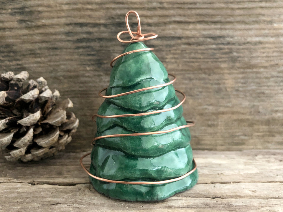Raku ceramic winter pine or spruce tree, glazed in green, with a spiral of copper wire going around it and ending in a star at the top.