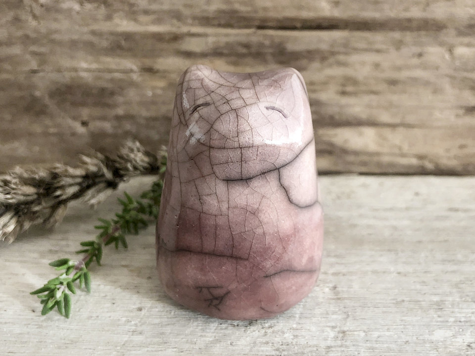 Raku ceramic sitting cat sculpture. This cat has a very friendly face and is glazed in a soft gradiant from dark to light mauve. It has a cute tail at the back.