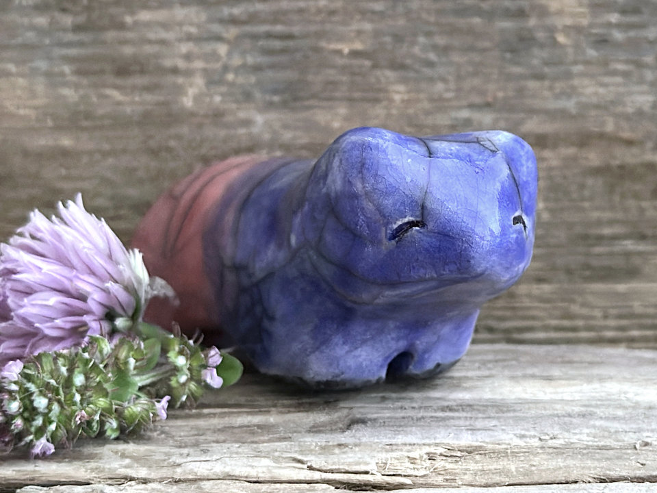 Ceramic raku bear kami sculpture glazed in a front-to-back gradient of indigo blue to soft red-pink. It has a kind, gentle face.