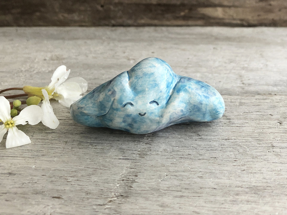Ceramic cloud sculpture glazed in pale blue and white with a very sweet, smiley face.