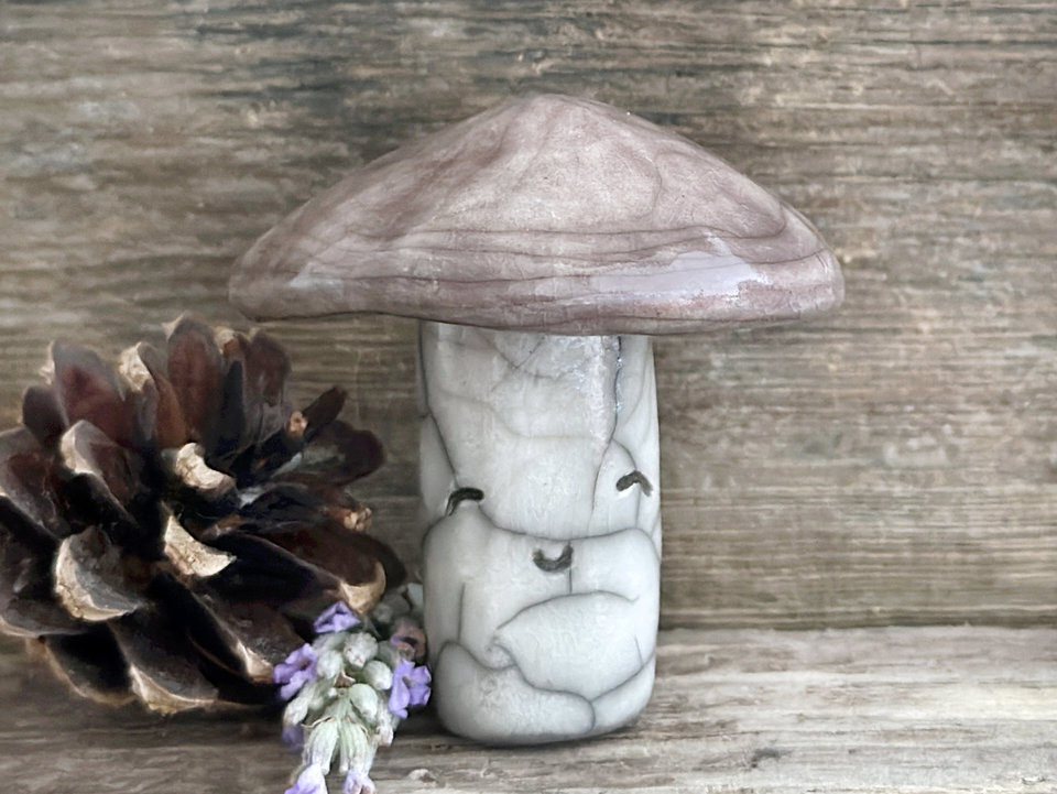 Cute mushroom raku ceramic sculpture with a very smiley face. Their stalk is glazed in creamy-white (this is where their face is) and their mushroom cap is brown.