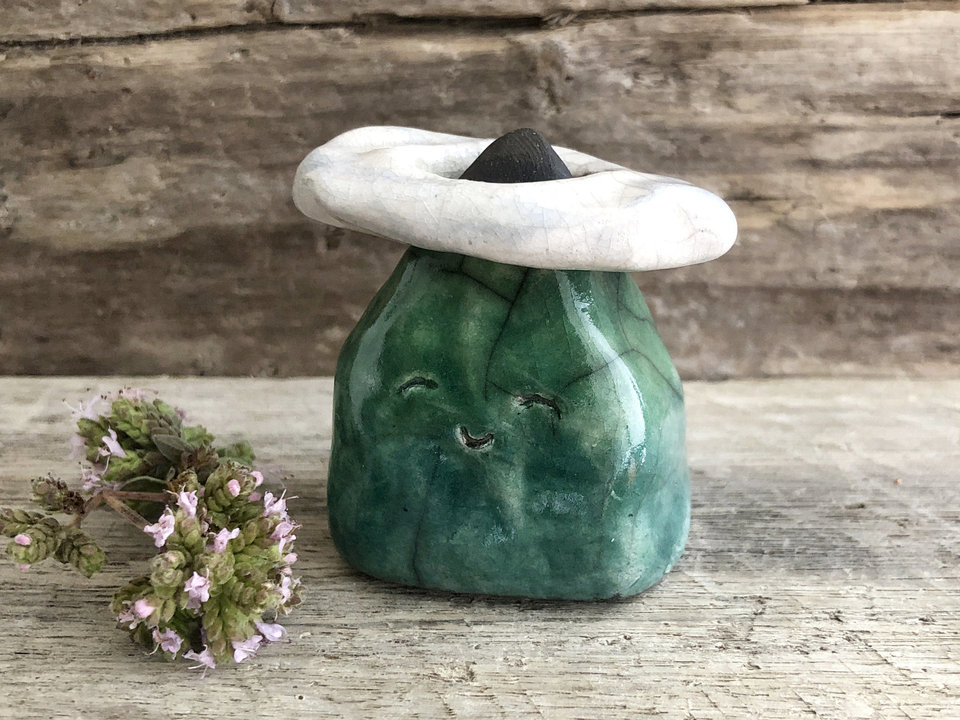 Raku ceramic sculpture of a smiley little mountain with its very own (removable) cloud ring! The mountain is glazed in shades of green and left black right at the very top, and the cloud is glazed in white and very pale blue.