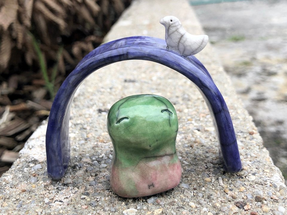 Ceramic raku kodama nature forest kami sculpture in pale green and pink. This guardian spirit comes with a blue arch with a white bird on top. Lovely for Shinto, shamanism, pagan, rewilding.