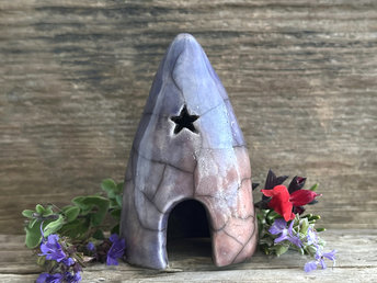Raku spirit cave with two little windows (including a star-shaped one) and a dome-shaped door. It's glazed in a combination of soft indigo, violet, mauve, and burnt orange.