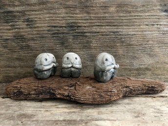Raku ceramic kodama nature spirits with sweet, gentle faces and little arms. They're glazed in a gradient from grey to almost white (bottom to top), and they sit on a long, flat piece of driftwood.