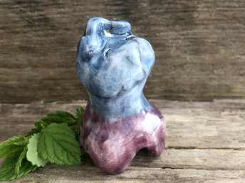 Raku ceramic sculpture of a sleep spirit. It's glazed in purple and blue and has a sweet, smiling, sleepy face.