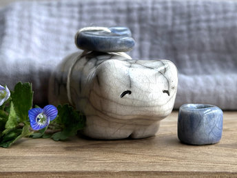 Raku ceramic white bear sculpture with a kind, gentle face. It carries a blue ceramic crescent moon on its back and has a little blue bowl too.