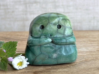 A sweet little kodama nature spirit ceramic guardian statue glazed in shades of green and with a lovely, gentle face and little arms.