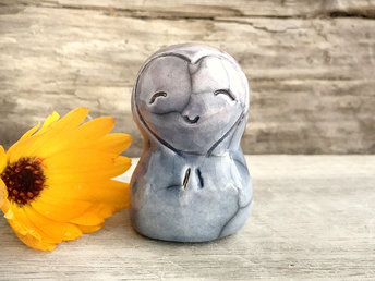 A smiley and loving Jizo Shinto raku ceramic sculpture talisman in soft, pale blue and violet with a heart shape around his kind, smiling face. A wonderful smooth shape to hold in the hand.