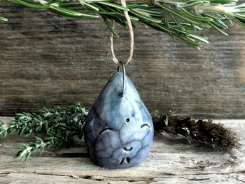 Raku ceramic tree ornament of a smiley, happy raindrop glazed in muted blue and turquoise colours.