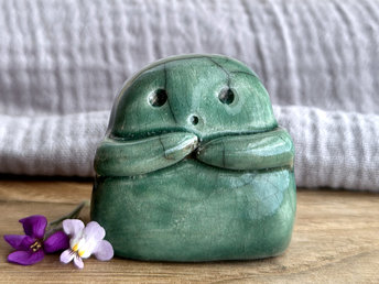 A sweet little kodama nature spirit ceramic guardian statue glazed in forest green and with a lovely, gentle face and little arms.