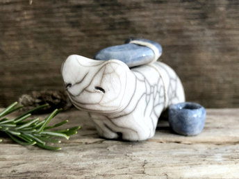 Raku ceramic white bear sculpture with a kind, gentle face. She carries a blue ceramic crescent moon on her back and has a little blue bowl too.