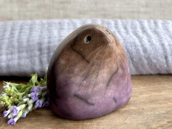 a lovely-to-hold little sculpture of a stylised mole friend. a bit like a large raindrop with a pointy nose? it's glazed in a bottom-t-o-top gradient of purple to warm brown and has a kind, gentle face.