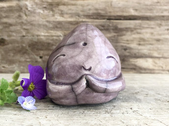 A smiley, loving, and very happy Jizo Shinto raku ceramic sculpture talisman glazed in a warm plum colour with sweet little praying hands.