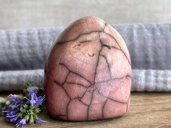 vaguely dome-shaped nature spirit ceramic sculpture. it is glazed in a bottom-to-top gradient of a soft bordeaux red to warm, soft orange. it has a gentle, smiling face.