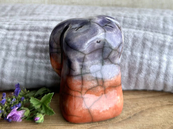 Raku ceramic usagi rabbit kami nature spirit glazed in a bottom-to-top gradient of warm red-orange to violet. Its ears are folded down its back, and it has a kind, gentle, smiling face.