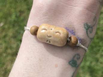 Golden-yellow raku ceramic cylindrical Shinto Jizo bead bracelet with two ethical sandalwood beads. It is strung on an adjustable eco-hemp cord. Jizo looks very happy and kind!