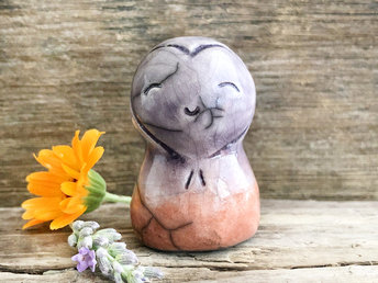 A smiley and loving Jizo Shinto raku ceramic sculpture talisman glazed in a bottom-to-top gradient of soft burnt orange to soft violet. She has a heart shape around her kind, gentle face and is a wonderful smooth shape to hold in the hand.