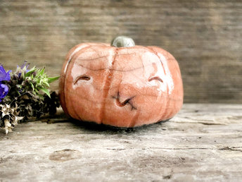 Raku ceramic orange pumpkin nature spirit kami sculpture with a very happy, smiley face.