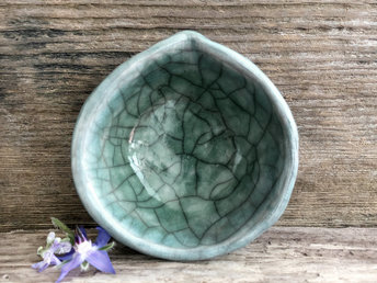 Raku ceramic offering bowl with a small spout. The bowl is glazed in soft blue and forest green with a beautiful raku crackle pattern.