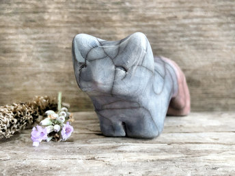 Raku ceramic kitsune fox sculpture glazed in a front-to-back gradient of soft blue to soft mauve pink. It has a kind, gentle face, and a tail curled over its back.