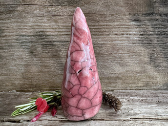 Raku ceramic sculpture of a tall, pointy gnome. He is very friendly and glazed in a warm, soft red colour.