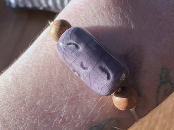 Light purple raku ceramic cylindrical Shinto Jizo bead bracelet with two ethical sandalwood beads. It is strung on an adjustable eco-hemp cord. Jizo looks very happy and kind!