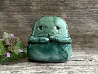 A sweet little kodama nature spirit ceramic guardian statue glazed in shades of green and with a lovely, gentle face and little arms.