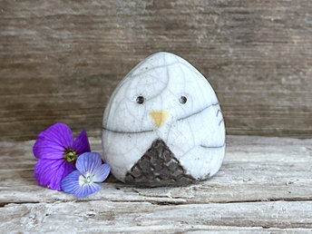 Raku ceramic little owl or owlet kami nature spirit statue glazed in white and grey-brown with gentle eyes and a little yellow beak.