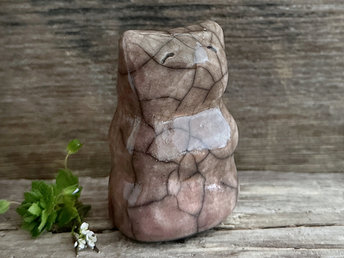 raku ceramic upright bear sculpture glazed in warm brown with hints of pink mauve. she has a happy, gentle face.