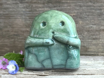 A sweet little kodama nature spirit ceramic guardian statue glazed in shades of green and with a lovely, gentle face and little arms.
